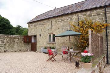 The front of Dairyman's Cottage with a pretty little sitting-out area, which is attached to Hatts Barn (2093).