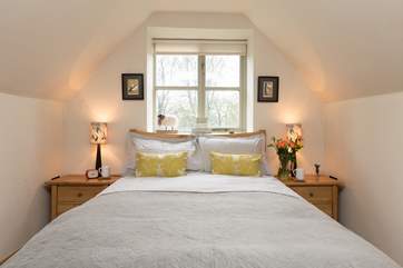 The spiral staircase opens directly into this comfortable and stylish bedroom.
