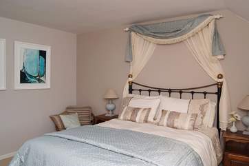 The spacious double bedroom has a king-size bed and gorgeous hand-made soft furnishings.