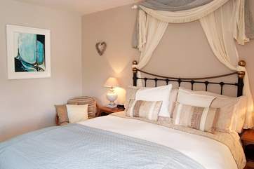 The colourful artwork really complements this lovely bedroom.