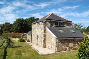The sunny enclosed garden wraps around the side and rear of the barn.