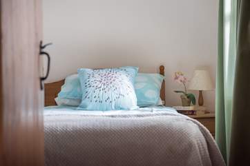 Comfy beds dressed in calm colours.