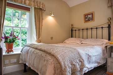 The bedroom has lovely linens and a gorgeous bedstead.