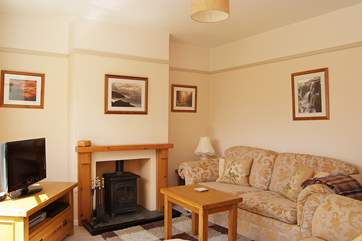 The cosy sitting-room includes a welcoming little wood-burner.