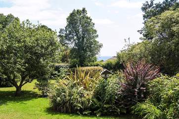 You can see the sea between the trees from the garden.