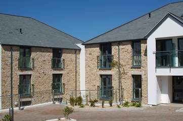 The front of the apartments and the gated parking-area.