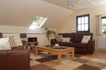 Leather sofas, soft cushions and a textured rug help you relax in comfort.