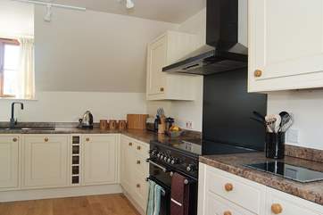 The kitchen has a contemporary black Rangemaster cooker.
