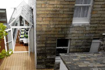 The raised decked-area at the end of the garden overlooks the back of the house.