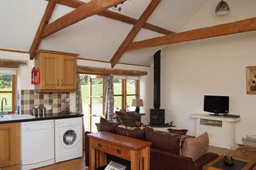 A low L-shaped sofa faces the welcoming wood-burner.