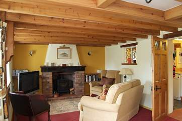 The cosy sitting/ dining room has a charming wood burner.
