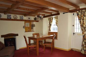At the dining end of the sitting/dining-room, the table is set beside the window.