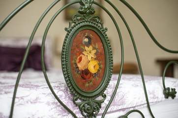 The decorative bed frame is a romantic touch.