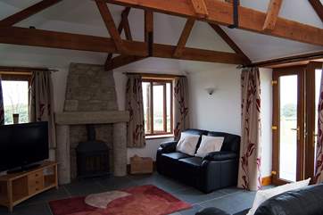 The sitting-area has a welcoming wood-burner and double doors leading outside to the patio and garden.