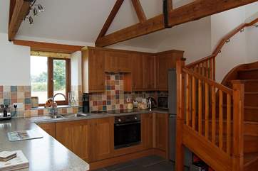 From the well-equipped kitchen a turning wooden staircase leads up to the first floor.