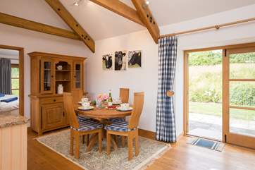 The dining-table is set in one corner of this spacious, high ceilinged open plan room.
