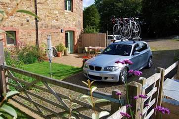 The rear view of The Garden House with parking for two cars alongside the private patio.