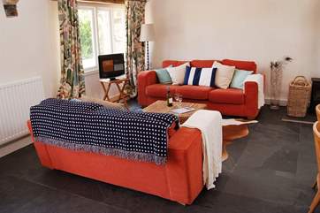 Inside there is a huge sofa, slate floors and a wood-burner.