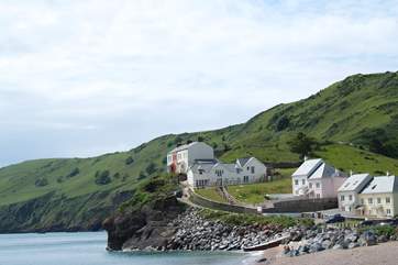 Casa Marinero is perched on the clifftop above the pebble beach (the house painted terracotta second in from the left).