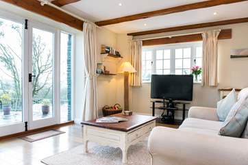 Large patio doors fill the room with light and give direct access to the grounds.