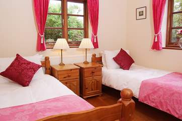 The twin bedroom (Bedroom 1) has windows on two sides, overlooking the garden.