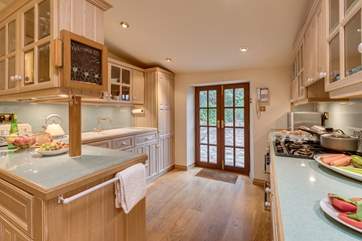 The kitchen is equipped as a home from home and has French windows to the stone terrace and garden.