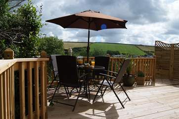 The sunny decked-area leads to the terraced lawned garden.