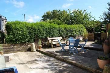 The private terraced courtyard behind the cottage catches the afternoon sun.