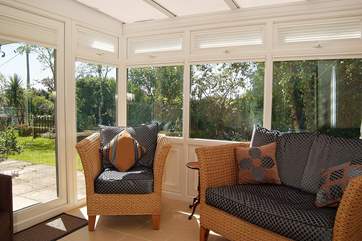The conservatory opens onto the patio and garden.