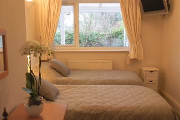 The pretty twin bedroom (Bedroom 2) has a wall-mounted television and overlooks the garden.