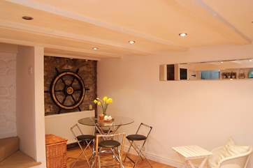 The clever use of a long mirror above the dining-table reflects light and gives the impression of a window in this lower ground floor room.
