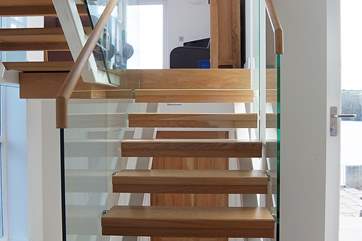 A half-flight of glass-sided, open-tread stairs leads from the entrance hall to the sitting-room.