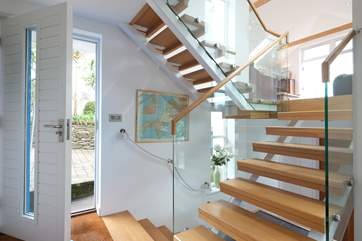 A half-flight of glass-sided, open tread stairs leads from the entrance hall to the sitting-room.