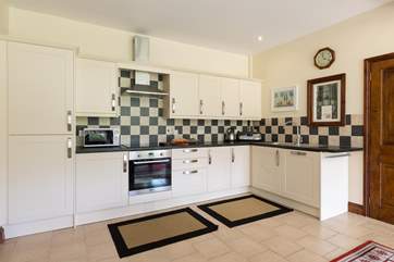 The extremely well-equipped kitchen is set at the far end of the dining-room. The utility-room is through the door to the right of the picture.