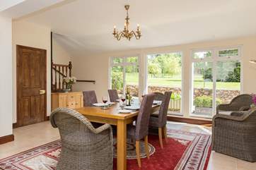 The spacious kitchen/dining-room looks out over the gardens. The stairs in the corner lead to the living-room.