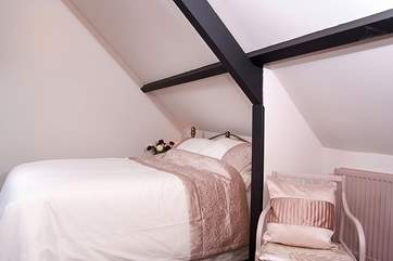 The bedroom has plenty of storage space and feels extra snug as the flue from the wood-burner is tucked into one corner.