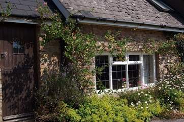 The friendly exterior of the cottage with its climbing roses.