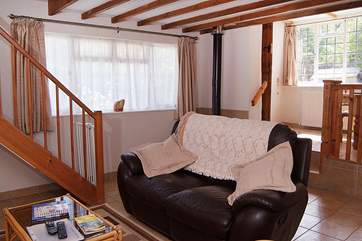 There is a cheerful open plan living area in this cottage. The dining-area is in the raised-area beyond.