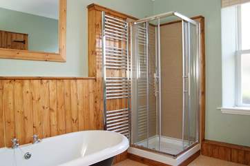 The bathroom has a shower cubicle as well as a roll-top bath.