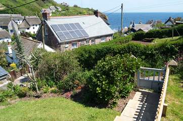Steps from the patio descend to the little garden gate which opens onto the footpath leading down to the cove.