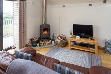 Another view of the living area with the wood burner, and full length shutters to keep you cosy in the winter.