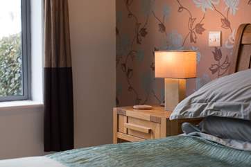 Pretty wallpaper adds warmth to the bedroom.