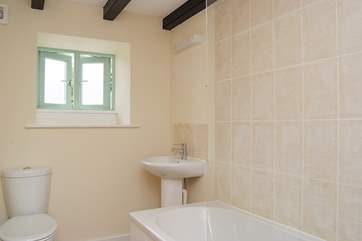 Bathroom with bath and fitted shower.