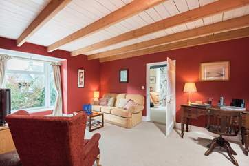 The unexpectedly spacious sitting-room at the centre of the cottage has the kitchen on one side and the cosy snug on the other.