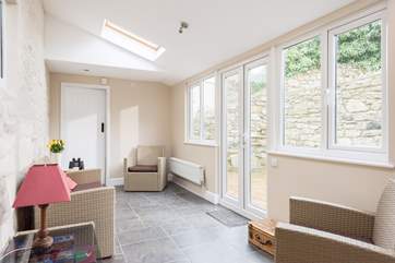 The sun-room links the ground floor shower-room and the rest of the cottage and gives access to the garden.