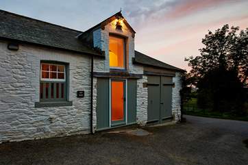 Th exterior of The Hay Barn at dusk with the sun slowly sinking in the west.