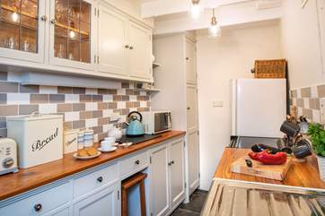 The pretty galley kitchen is perfectly in keeping with the cottage