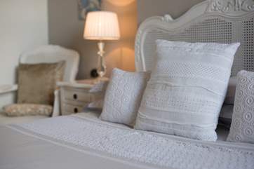 Pretty lace cushions complement the linens.