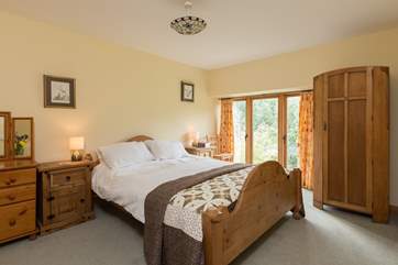 Back inside, this is the master bedroom on the first floor. Floor to ceiling windows give you wonderful views from your bed