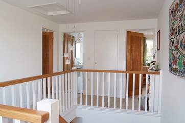 The wide, light landing at the top of the stairs looks down over the spacious entrance hall.